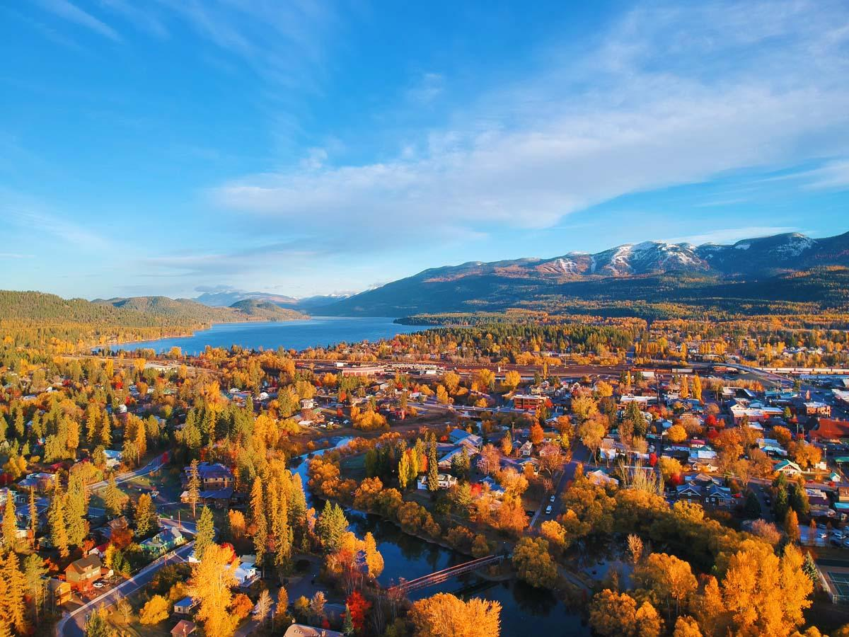 Aerial view of Whitefish, Montana in autumn with Whitefish Lake, the town, and snow-capped mountains in the distance