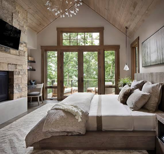 Montana bedroom with a vaulted wood ceiling and doors opening to the trees