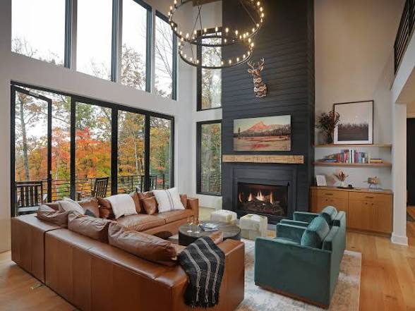 Montana living room with a two-story window wall and a black stone fireplace